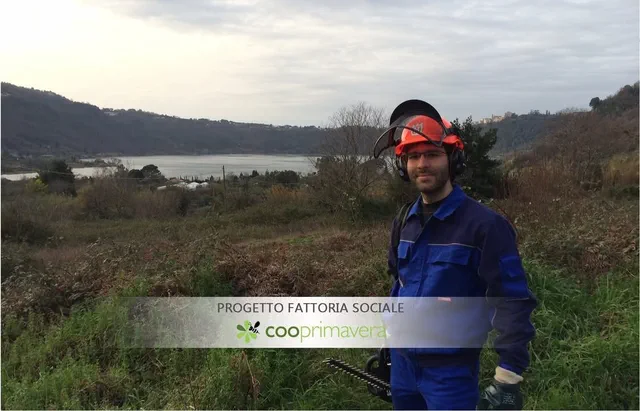 Operatore Cooprimavera sul terreno da bonificare, con il lago di Nemi alle spalle